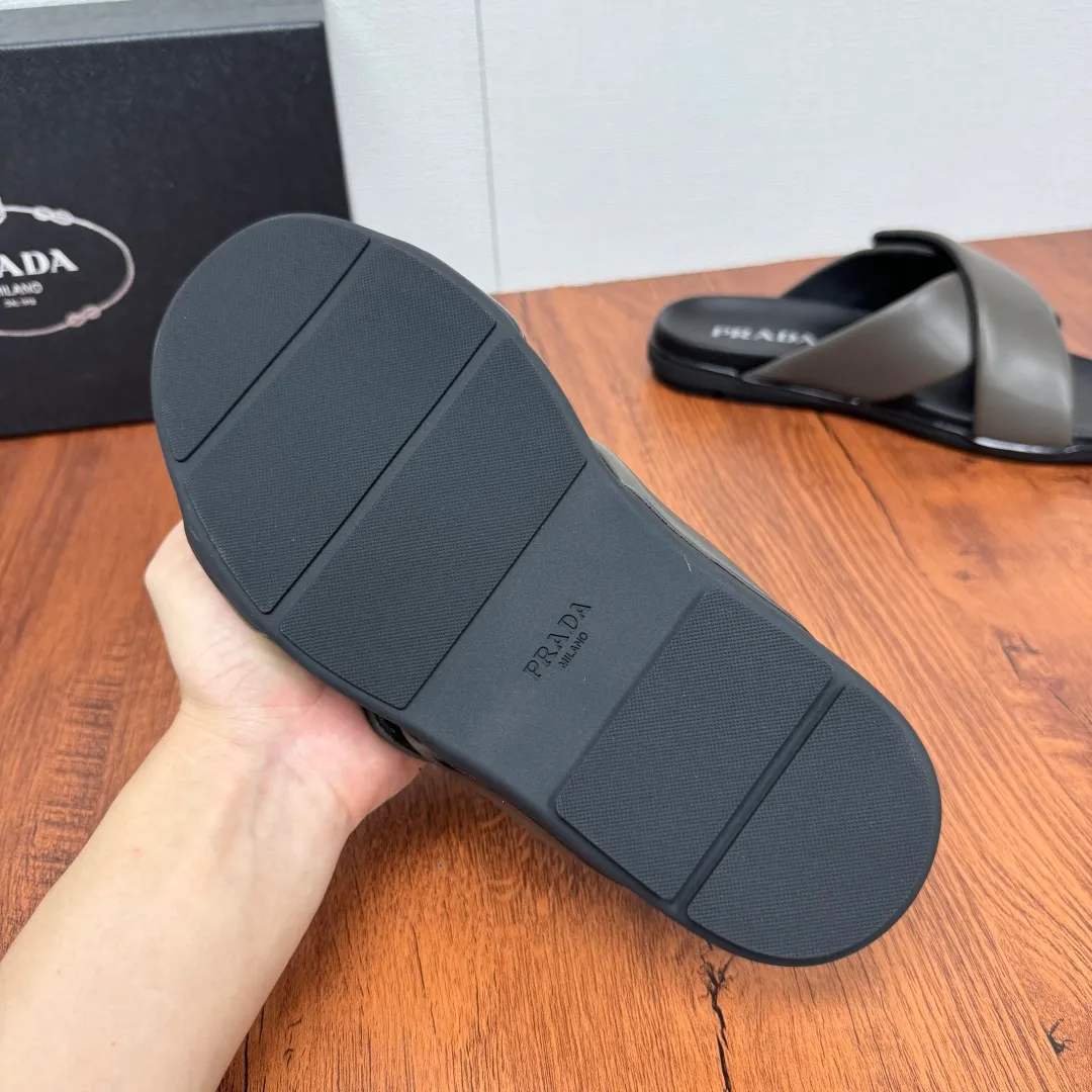 Batch 580 Prada/Prada's new men's leather cross slippers. Velcro closure can finely adjust the size. Calf leather light luxury slippers. Thick soft calf leather wraps the upper. Fat but soft rubber lazy style, soft and comfortable, excellent foot feel. Genuine leather bottom layer, cross style, with a Velcro closure buckle, easy to adjust the appropriate size, and a perfect fit for the wearing experience. The enamel gold triangle logo highlights the brand's classic features. Lightweight rubber thin sole, high foot comfort! Complete package! Size: 39-40-41-42-43-44-45 Leather shoe size Item number: 2X7132 Gray